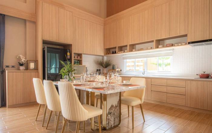 Narita Villa narrow side garden pathway with stepping stones, small trees, and decorative wall features.