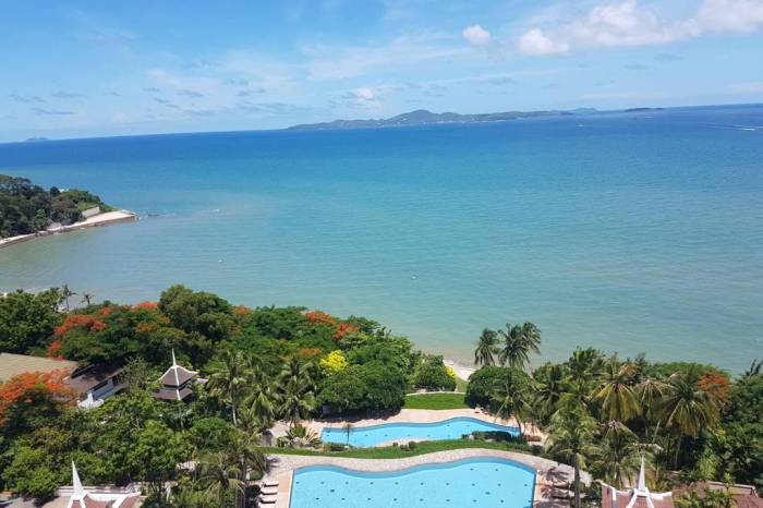 Royal Cliff Garden aerial view of two large outdoor pools, green landscape, and blue ocean with islands.