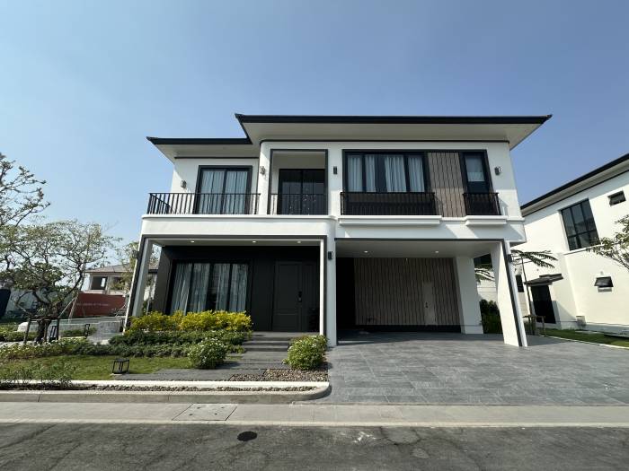 Chieftain modern two-story house with white facade, black trim, large windows, and a covered parking area.