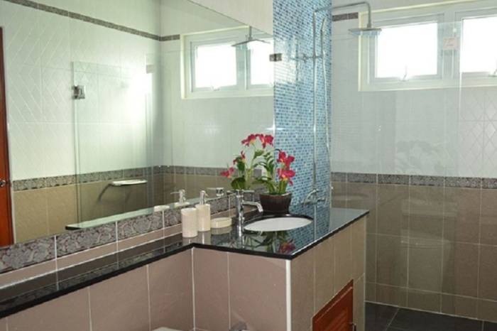 Amorn Village house exterior with a private swimming pool, outdoor seating area, and lush green landscaping.