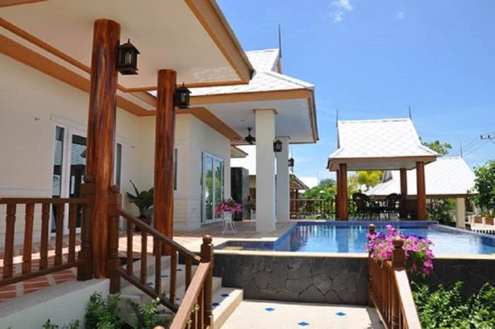 Amorn Village exterior with a swimming pool, wooden stairs, covered patio, and a traditional Thai style gazebo.