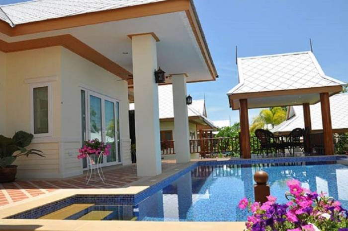 Amorn Village house exterior showing a swimming pool, a covered patio with columns, and a traditional Thai gazebo.
