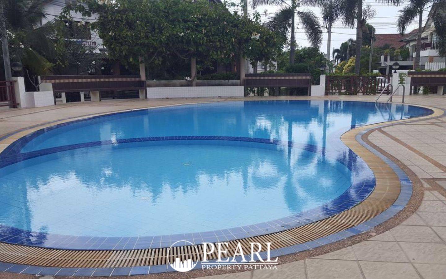 Central Park 4 outdoor children's playground with colorful slides, swings, and palm trees on a grassy lawn.