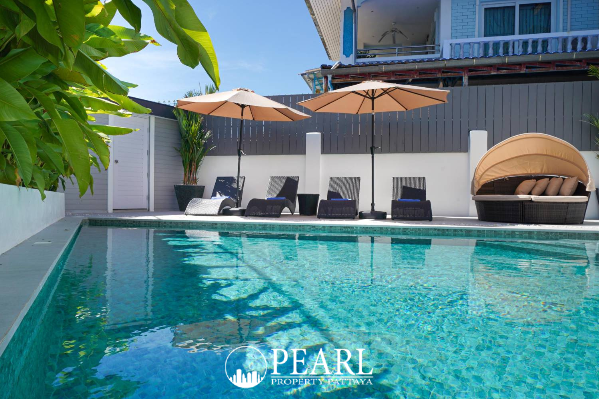 Grand Tanyawan Home large community swimming pool with houses and blue sky in the background.