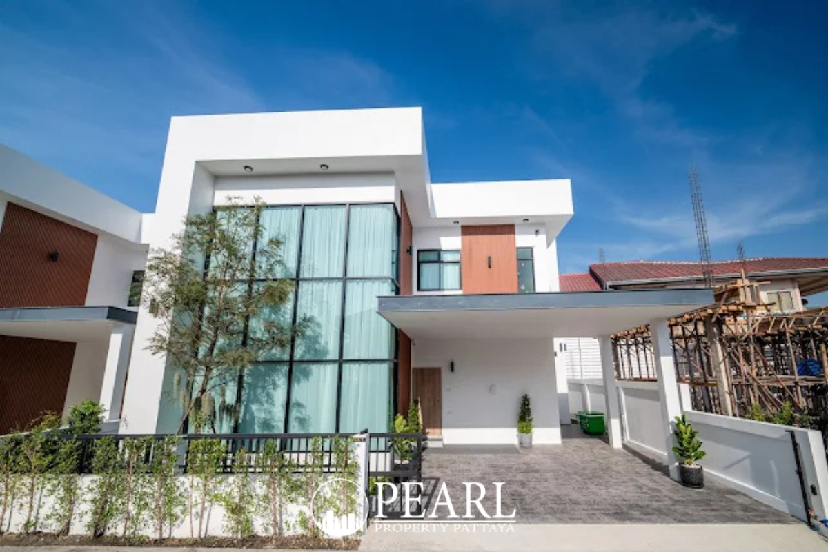 The Image shows a modern white house exterior with large glass windows, a small swimming pool, and outdoor seating.