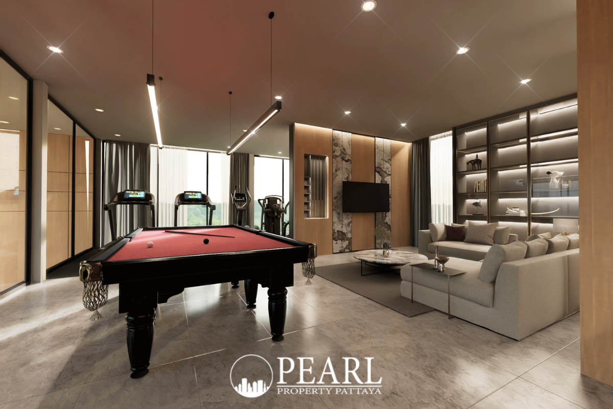 Baan Mae 12 – Onyx Grand Village entertainment room with a red pool table, sofa, and gym equipment.