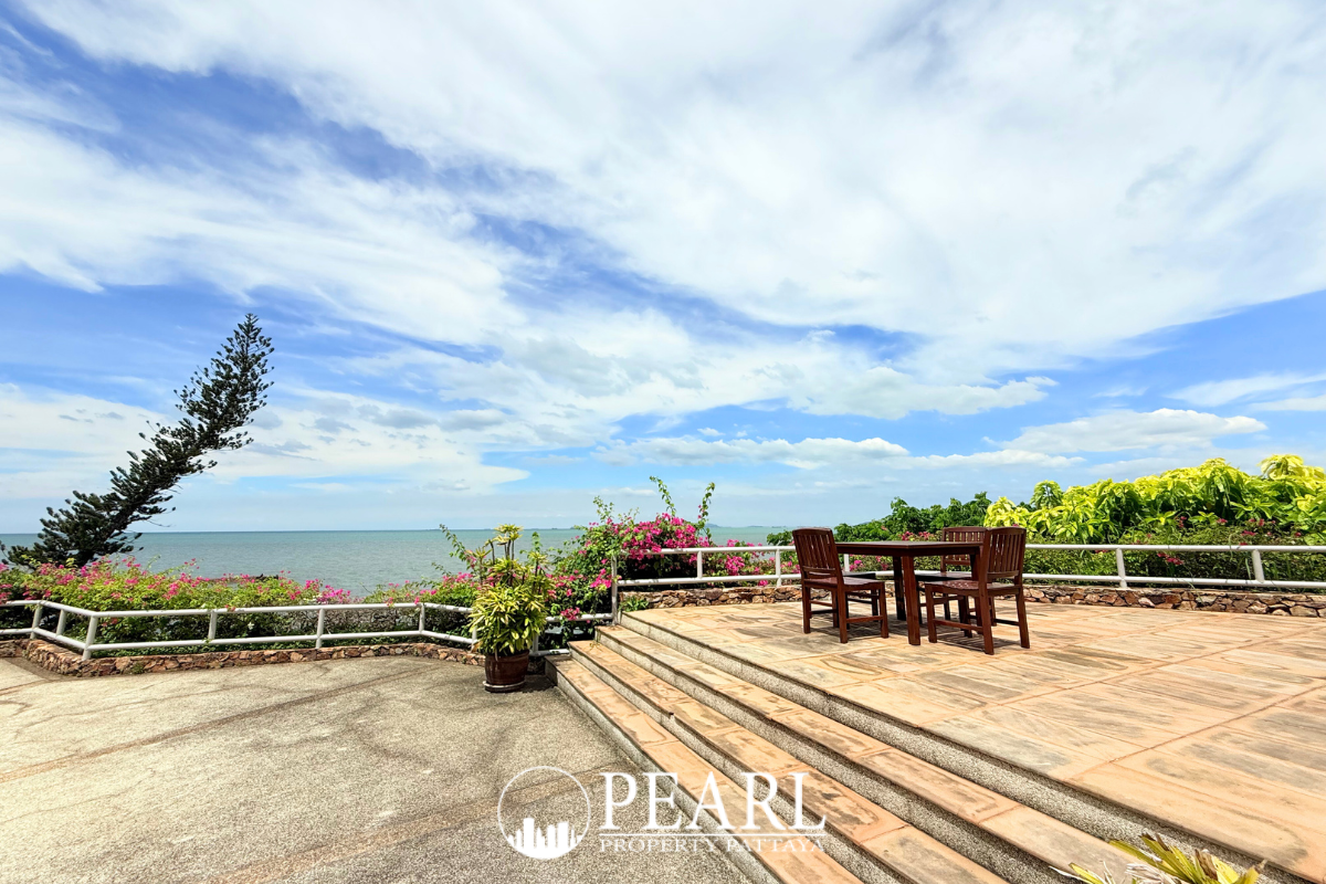 Garden Cliff Condominium 1 expansive outdoor swimming pool with a covered seating area and ocean in the background.