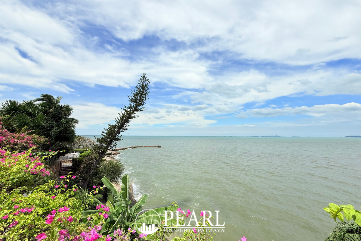 Garden Cliff Condominium 1 scenic pathway leading to a white gate with ocean views and tropical trees.