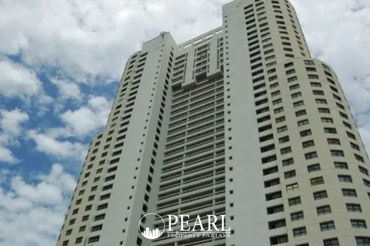 Metro Jomtien Condotel: Exterior of the condotel building with red accents, surrounded by lush trees and a pool area.