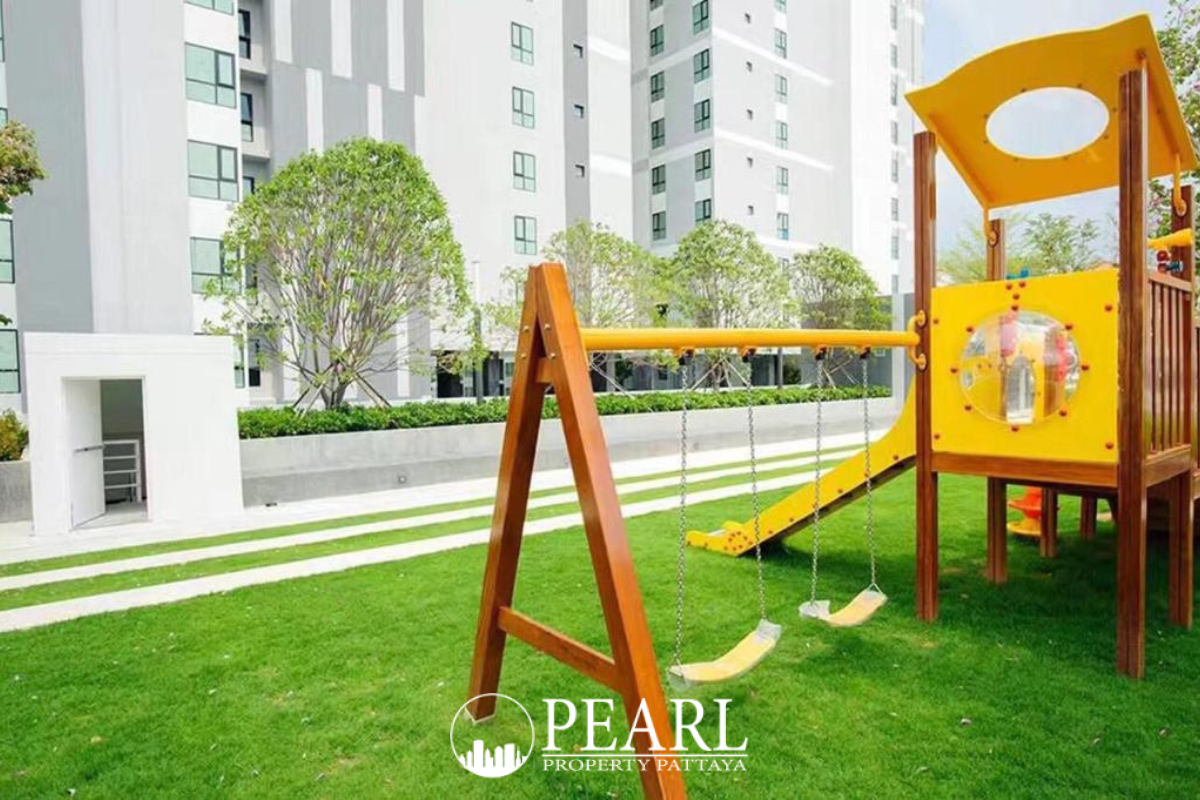 The Base Central Pattaya communal lounge area with city views, large windows, and modern lighting.