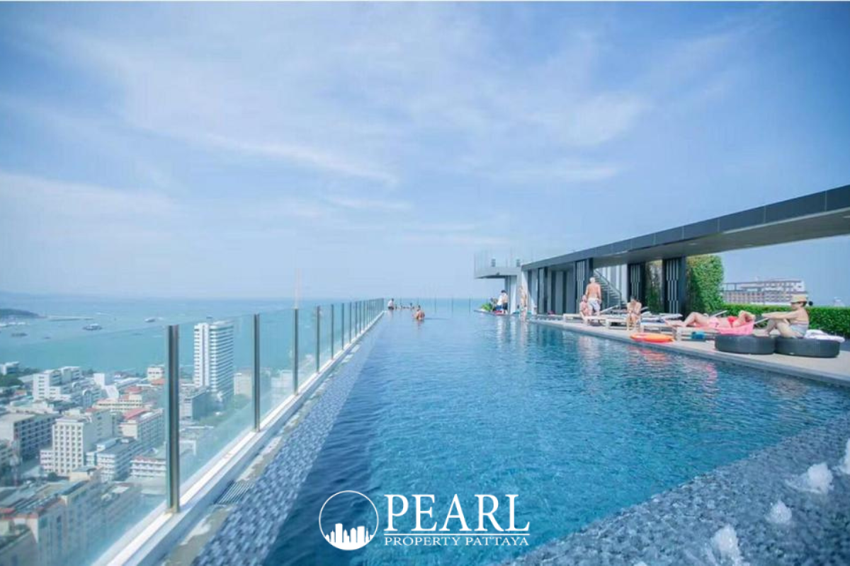 The Base Central Pattaya illuminated entrance and tall condominium buildings at night.